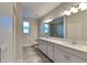 Bright bathroom featuring double vanity, gray wood-look tile floor, and a large mirror at 8563 Starlight Loop, Parrish, FL 34219