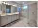 Modern bathroom featuring double sinks, a walk-in shower with glass enclosure and stylish fixtures at 8563 Starlight Loop, Parrish, FL 34219