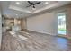 Open-concept living room and kitchen with abundant natural light and wood-style tile flooring at 8563 Starlight Loop, Parrish, FL 34219