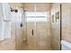 Close-up of the bathroom's glass-enclosed shower with tile and a shower caddy at 9016 Bay Ne St, St Petersburg, FL 33702