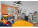 Bright bedroom features wood floors, ceiling fan, playful decor, and lots of natural light at 9067 Cypress Trl, Seminole, FL 33777
