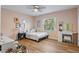 Cozy bedroom with wood floors, a large window, and a charming vanity with a stool at 9067 Cypress Trl, Seminole, FL 33777