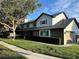Traditional two-story home featuring brick accents, a well-kept lawn, and mature trees at 9067 Cypress Trl, Seminole, FL 33777