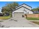 Attached two-car garage with a basketball hoop and a driveway, offering ample parking space at 9067 Cypress Trl, Seminole, FL 33777