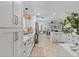Open concept kitchen with white cabinetry, farmhouse sink, gold hardware, and stainless steel refrigerator at 9067 Cypress Trl, Seminole, FL 33777