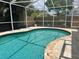 Sparkling, clean in-ground pool with beautifully tiled edging, under a screened enclosure at 9067 Cypress Trl, Seminole, FL 33777