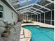 Outdoor pool area with a screened-in enclosure, a spa, and comfortable seating at 9067 Cypress Trl, Seminole, FL 33777