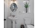 Charming powder room featuring a pedestal sink and a decorative mirror at 9067 Cypress Trl, Seminole, FL 33777