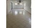 A spacious living room filled with light from multiple windows, featuring tile flooring and a ceiling fan at 9331 Mark Twain Ln, Port Richey, FL 34668