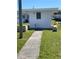 Exterior view of a white building with window and walkway leading to the entrance at 10002 Daffodil N St # 51, Pinellas Park, FL 33782