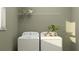 Well-lit laundry room with white appliances and an overhead storage shelf at 11563 71St E Ave, Palmetto, FL 34221