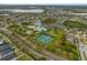 Experience an aerial view showcasing tennis courts, a pool, and a pond amidst a friendly neighborhood at 12339 Silton Peace Dr, Riverview, FL 33579