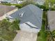 Aerial view of a well-maintained home showcasing a gray roof, a two-car garage, and verdant landscaping at 12339 Silton Peace Dr, Riverview, FL 33579