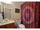 Bathroom featuring dark wood vanity, framed mirror, toilet, and colorful patterned shower curtain at 12339 Silton Peace Dr, Riverview, FL 33579