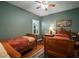 Charming bedroom featuring hardwood floors, ceiling fan, two twin beds, desk, and decorative accents at 12339 Silton Peace Dr, Riverview, FL 33579