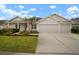 Attractive home with a well-manicured lawn, vibrant flower beds, and a spacious two-car garage enhances curb appeal at 12339 Silton Peace Dr, Riverview, FL 33579