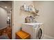 Laundry room with shelving stocked with cleaning products, wooden storage bench and updated appliances at 12339 Silton Peace Dr, Riverview, FL 33579