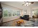 Bright living room featuring hardwood floors, ceiling fan and large windows with plantation shutters at 12339 Silton Peace Dr, Riverview, FL 33579