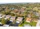 Aerial view showcasing the neighborhood and nearby tennis courts and lake at 12411 Eagleswood Dr # B, Hudson, FL 34667