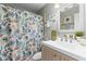 Bathroom with unique shower curtain, framed mirror, and neutral vanity, creating a comfortable and stylish space at 12411 Eagleswood Dr # B, Hudson, FL 34667