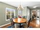 Cozy dining area with natural light from the large windows, accented by a stylish chandelier above round table at 12411 Eagleswood Dr # B, Hudson, FL 34667