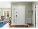 Bright entryway featuring a white door with decorative glass, hardwood floors, and soft green walls at 12411 Eagleswood Dr # B, Hudson, FL 34667