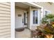 Inviting front entrance with decorative door, 'Welcome' sign, siding, and colorful foliage at 12411 Eagleswood Dr # B, Hudson, FL 34667