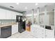 Bright kitchen with white cabinets, black appliances, and a view into the dining and living areas at 12411 Eagleswood Dr # B, Hudson, FL 34667