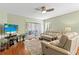 Comfortable living room with leather furniture, ceiling fan, sliding door to patio, and natural lighting at 12411 Eagleswood Dr # B, Hudson, FL 34667