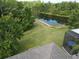 Expansive backyard featuring lush greenery, a serene pond, and a screened lanai at 14116 Trouville Dr, Tampa, FL 33624