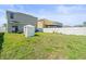 Spacious backyard with a white fence, grassy lawn and a backyard cabana at 14422 Scottburgh Glen Dr, Wimauma, FL 33598