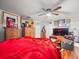 Main bedroom with red bedding, wood floors, and art-filled walls at 14422 Scottburgh Glen Dr, Wimauma, FL 33598