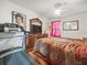 Bedroom with hardwood floors, ceiling fan, dresser, and red-themed decor, featuring a treadmill at 14422 Scottburgh Glen Dr, Wimauma, FL 33598