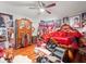 Bedroom featuring an armoire, red bedding, and walls covered with framed pictures at 14422 Scottburgh Glen Dr, Wimauma, FL 33598