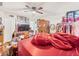 Bedroom featuring red bedding, wood floors, armoire, and a tv at 14422 Scottburgh Glen Dr, Wimauma, FL 33598