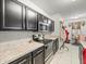 Modern kitchen with stainless steel appliances and sleek black cabinetry at 14422 Scottburgh Glen Dr, Wimauma, FL 33598