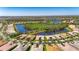 Aerial view of home in a lakeside community surrounded by lush green trees and landscaping at 15657 Aurora Lake Cir, Wimauma, FL 33598