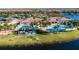 Stunning aerial view showcasing the community pool, clubhouse, and lush landscaping with lake views at 15657 Aurora Lake Cir, Wimauma, FL 33598
