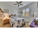 Quaint bedroom featuring a comfortable bed, ceiling fan, and ample natural light from a shuttered window at 15657 Aurora Lake Cir, Wimauma, FL 33598