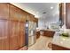 Open-concept kitchen with granite countertops, stainless steel appliances, and ample wooden cabinetry at 15657 Aurora Lake Cir, Wimauma, FL 33598
