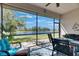 Relaxing screened lanai with lake view, comfortable seating, ceiling fan, and outdoor grill at 15657 Aurora Lake Cir, Wimauma, FL 33598