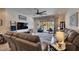 Bright living room featuring a ceiling fan, plush couches, and a view of the screened patio with a water view at 15657 Aurora Lake Cir, Wimauma, FL 33598