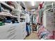 Spacious walk-in closet with custom shelving and drawers, providing ample storage for clothes and accessories at 15657 Aurora Lake Cir, Wimauma, FL 33598