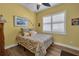 Yellow bedroom with a ceiling fan, patterned bedding, and a bright sunny feel at 16021 Golden Lakes Dr, Wimauma, FL 33598