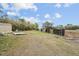 Expansive backyard with a shed and wooden platform under a sunny sky at 17558 Caufield Rd, Spring Hill, FL 34610