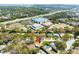 Aerial view showing the home with a red arrow for emphasis in a wooded neighborhood at 1830 Oak Forest S Dr, Clearwater, FL 33759
