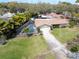 Aerial front view featuring a charming home with screened pool, manicured lawn, and two-car garage at 1830 Oak Forest S Dr, Clearwater, FL 33759