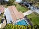 Aerial view of home, highlighting the pool and spa, green lawn, and neighborhood setting at 1830 Oak Forest S Dr, Clearwater, FL 33759