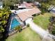 Aerial view of a home featuring a screened pool, spacious backyard, and tree-lined streets at 1830 Oak Forest S Dr, Clearwater, FL 33759
