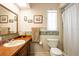 Bathroom featuring a wood vanity, large mirror, and floral wallpaper at 1830 Oak Forest S Dr, Clearwater, FL 33759